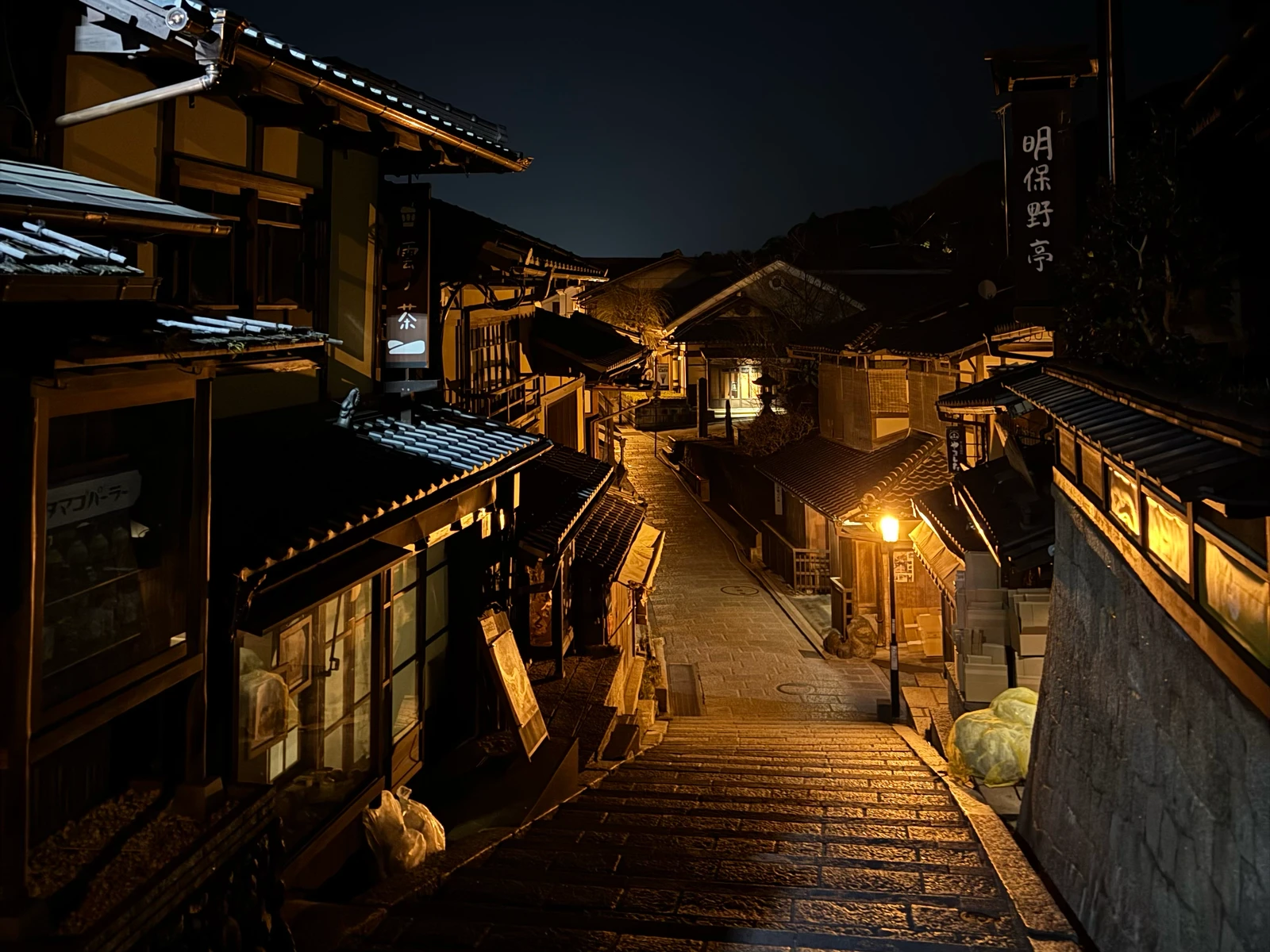 Stone steps descending between traditional buildings at night.